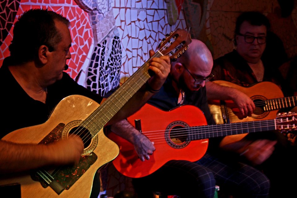 Tres guitarristas tocando juntos en el tablao